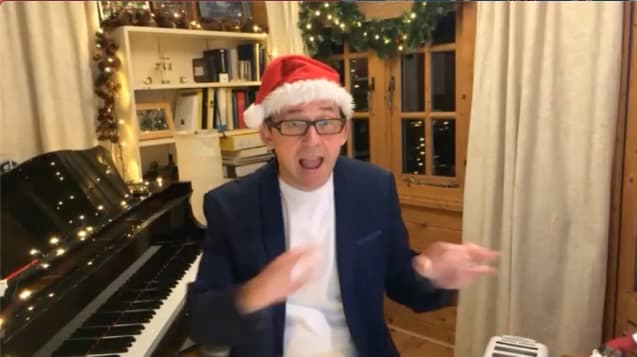 Will Todd sat near a piano wearing a Santa hat